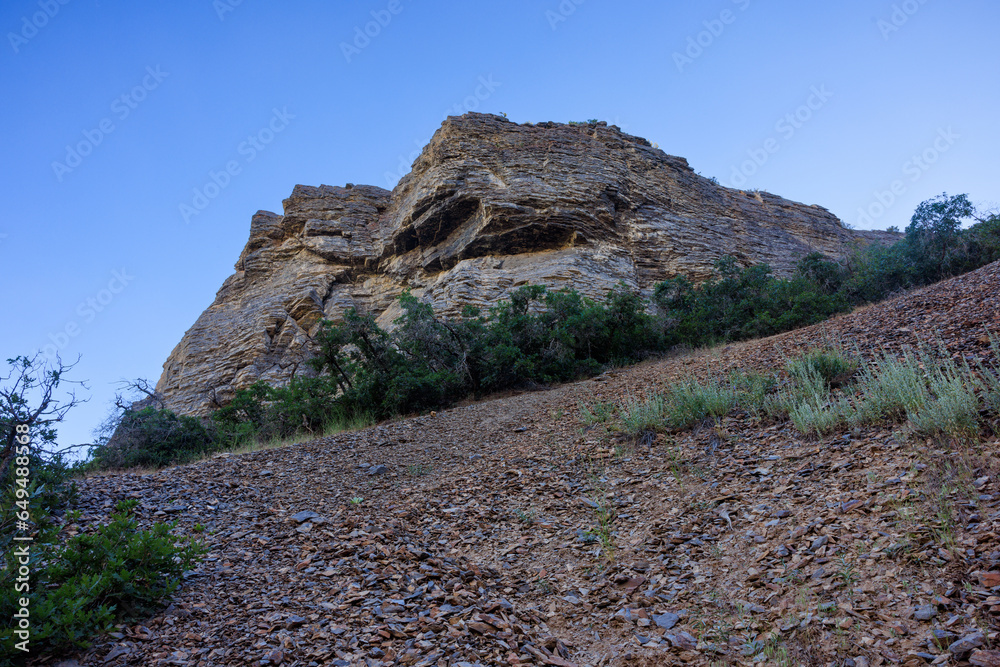 round mountain sitting atop rocky slope