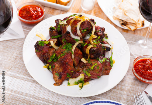 Traditional oriental grilled pork meat shashlik with onion and fresh herbs
