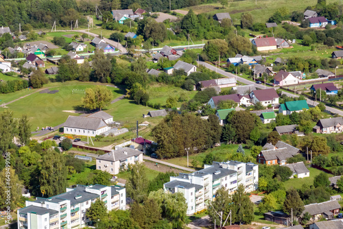 panoramic aerial view of small provincial town or big eco village with wooden houses, gravel road, gardens and orchards © hiv360