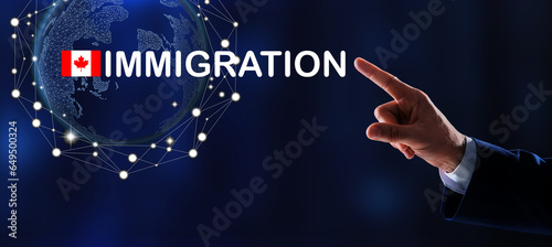 Immigration. Businessman touching digital screen with world globe, word and flag of Canada on dark blue background, closeup photo