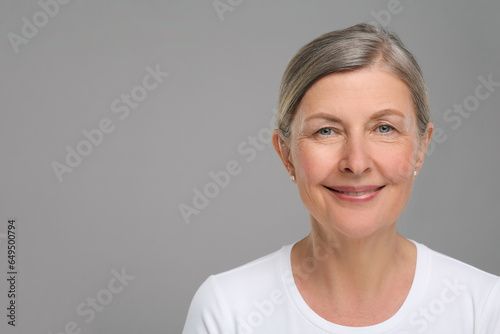 Portrait of senior woman with aging skin on grey background, space for text. Rejuvenation treatment