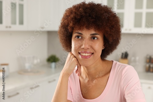 Portrait of happy young woman in kitchen. Space for text