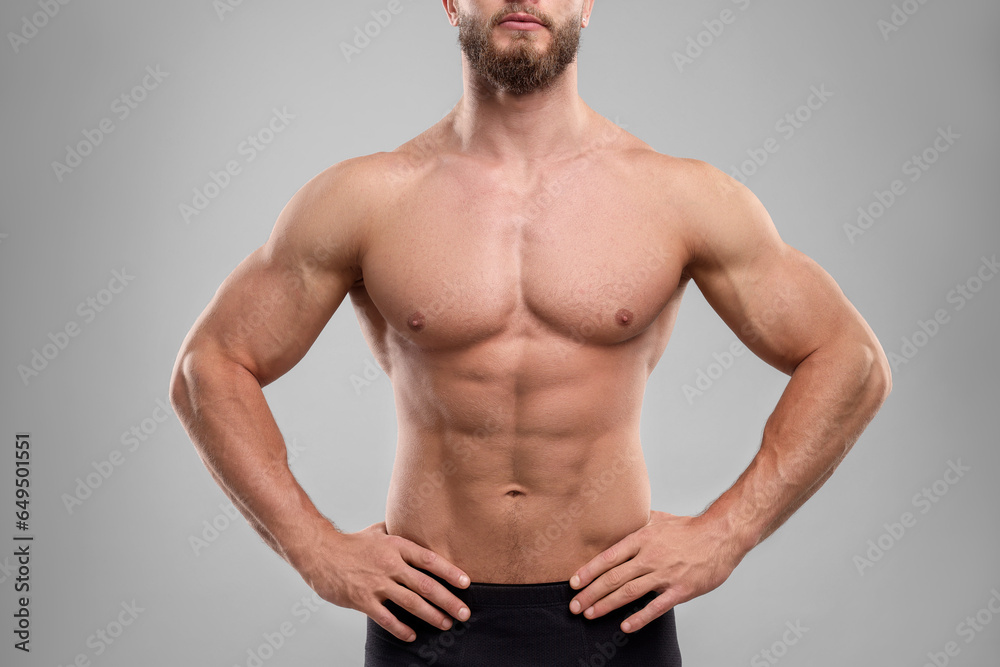 Muscular man showing abs on light grey background, closeup. Sexy body