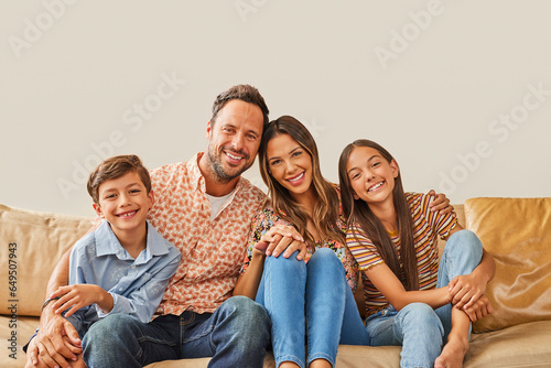 Portrait of smiling family with two children (8-9, 12-13) sitting on sofa photo