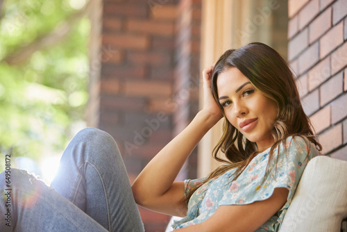 Portrait of mid adult woman relaxing on sofa on patio photo