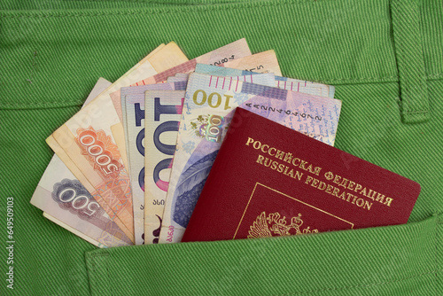 Top view. Russian biometric passport. Cash money of Russia and Georgia in pocket of green jeans. Ruble. Georgian lari. 100 GEL. Concept of currency exchange, immigration, citizenship, travel, shopping