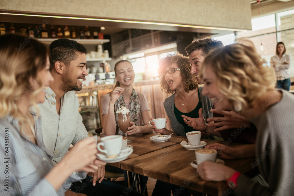Young and diverse group of people having coffee together at a cafe in the city