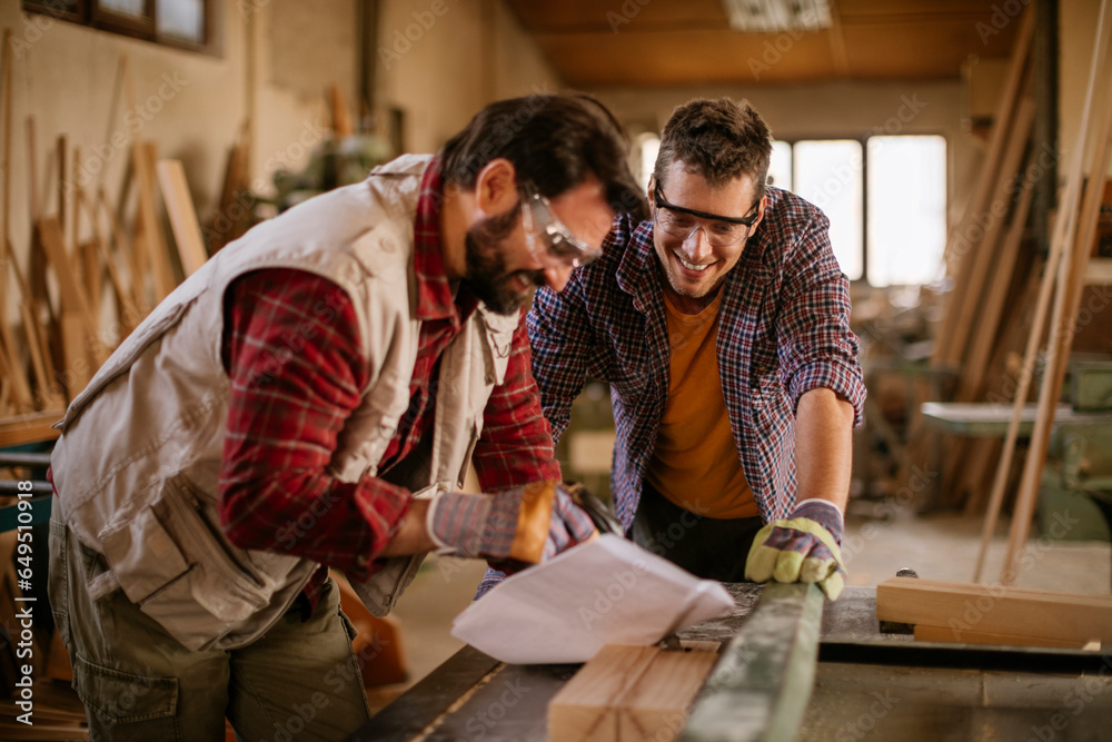 Two male carpenters working in a wood shop Two male carpenters working in a wood shop