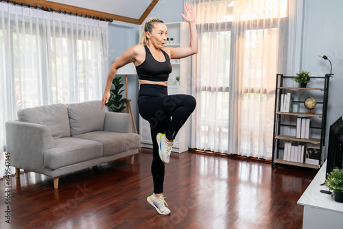 Athletic and sporty senior woman make running pose at home. Healthy fit body lifestyle as home workout exercise concept after retirement in full body shot. Clout