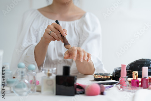 Asian female video blogger to review cosmetics. Influencer beauty blogger broadcasts makeup tools  lipsticks  powders  buffs  perfumes how to do makeup for social followers in the office