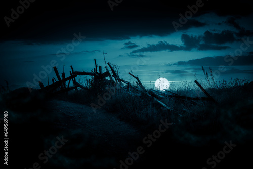 Horror night landscape with an old broken fence under the full moon. Halloween background. © stone36