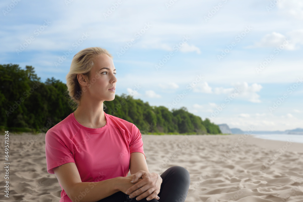 Portrait of calm relaxed beautiful fitness girl sitting on the seashore