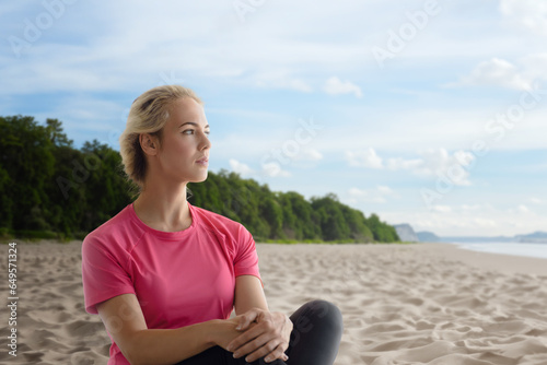 Portrait of calm relaxed beautiful fitness girl sitting on the seashore © Denys Kurbatov