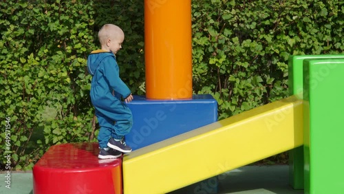 toddler child in amusement park, happy little boy climbing on colorful cubes. Divo Ostrov, St. Petersburg, Russia photo