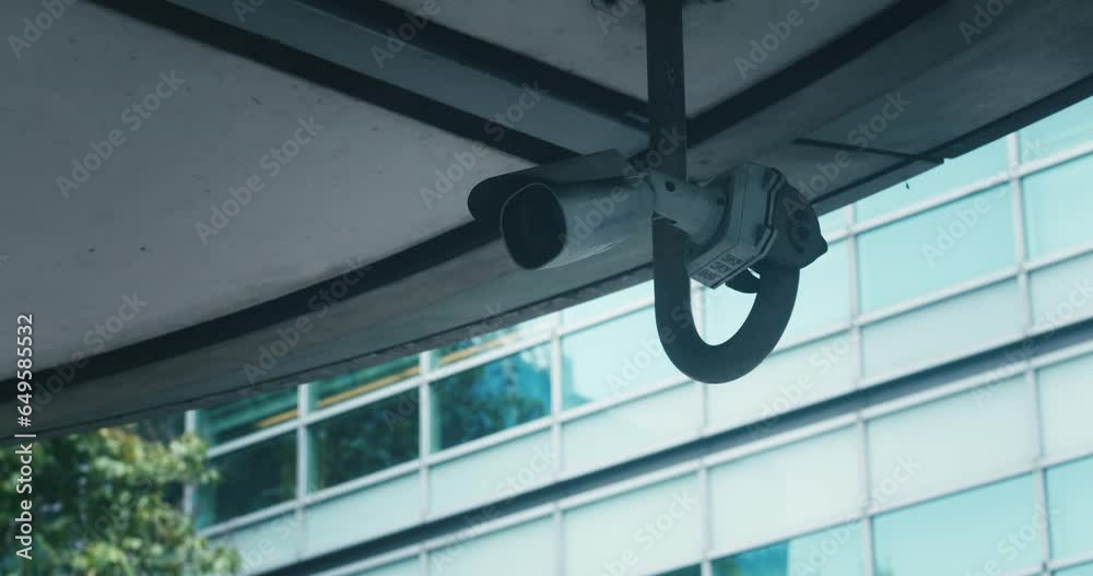 Video surveillance camera system installed on city streets. Cctv camera security system scanning street in big city. Security video camera at the corner of building moving and scanning street area