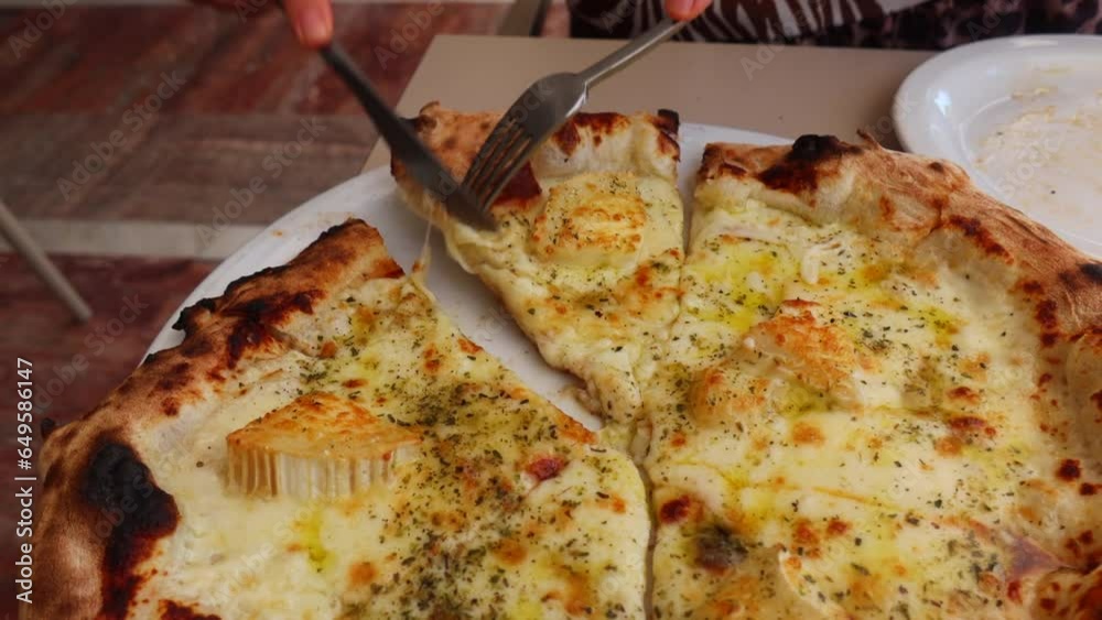 Cutting and picking up a traditional Italian goat cheese truffle honey