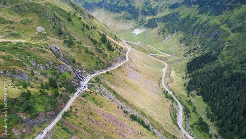 Slow push in aerial dolly of Transfagarasan Serpentine Road waterfall and valley hairpin turn
 photo