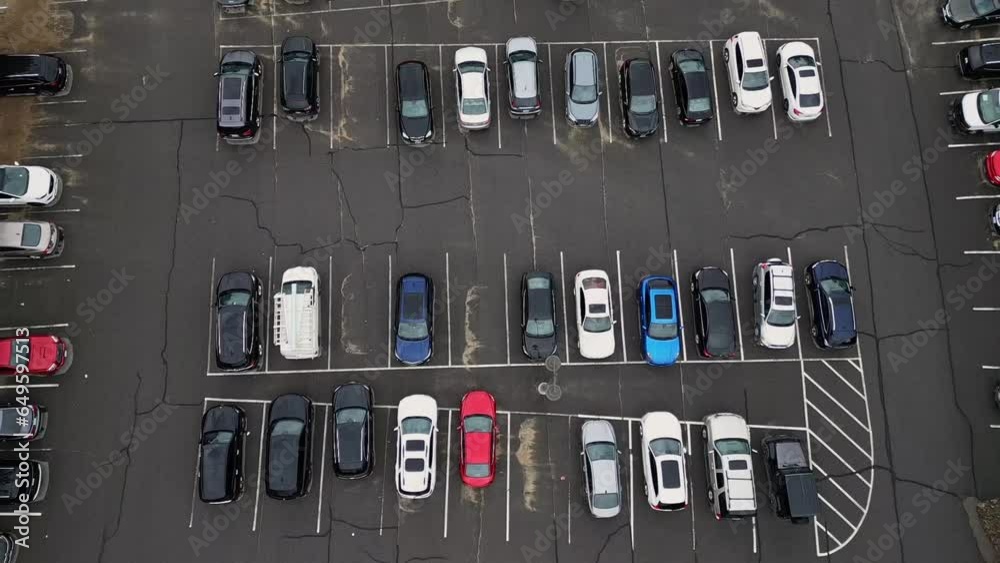 Rows Of Cars Parked In An Open Parking Lot At Daytime. aerial pullback
