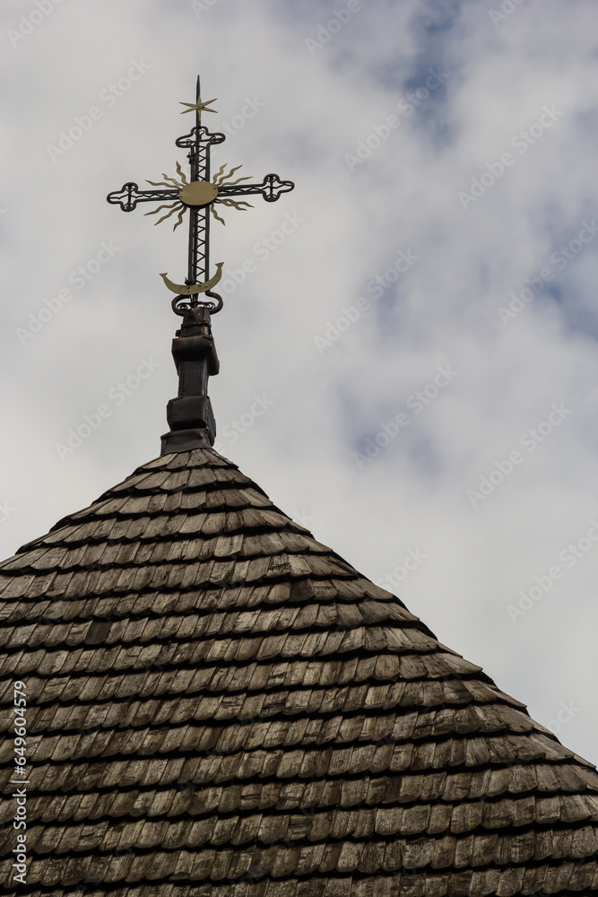 old wooden church against the blue sky in Ukraine, wooden roof with a cross old wooden church against the blue sky in Ukraine, wooden roof with a cross