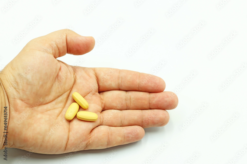 A hand showing vitamin pills or medicines A hand showing vitamin pills or medicines
