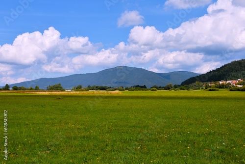 Field at lake Cerknica and Slivnica hill in the background in Notranjska, Slovenia