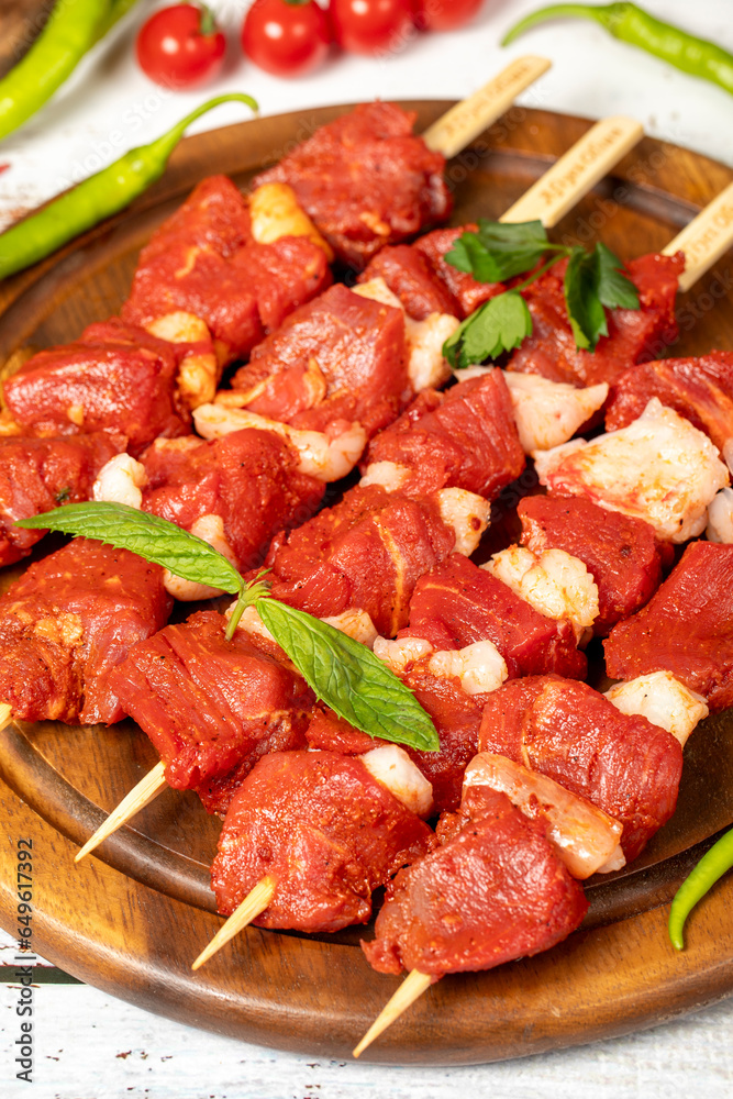 Beef tenderloin skewer on wood background. Beef tenderloin skewer with raw sauce with herbs and spices. Close up Beef tenderloin skewer on wood background. Beef tenderloin skewer with raw sauce with herbs and spices. Close up