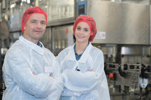 biologist team talking and wearing hairnet in the factory