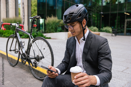 Young man in a suit and protective hempet with a coffee cup in hand photo