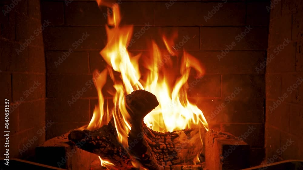 Home fireplace with red flame and firewood. 4K video relaxing endless footage