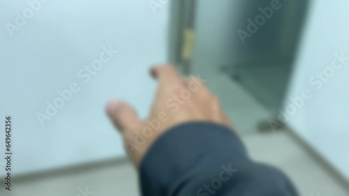 First person point of view walking in office room feeling dizzy white wall interior blurry motion right hand try to reach for glass door handle and falling on the ground floor and become unconscious
