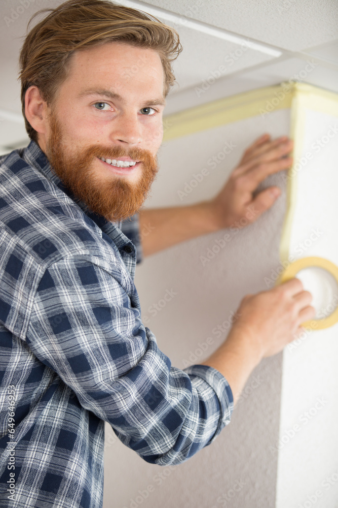 man putting tape on the wall man putting tape on the wall