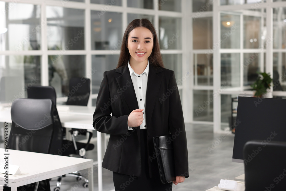 Happy real estate agent with leather portfolio in office