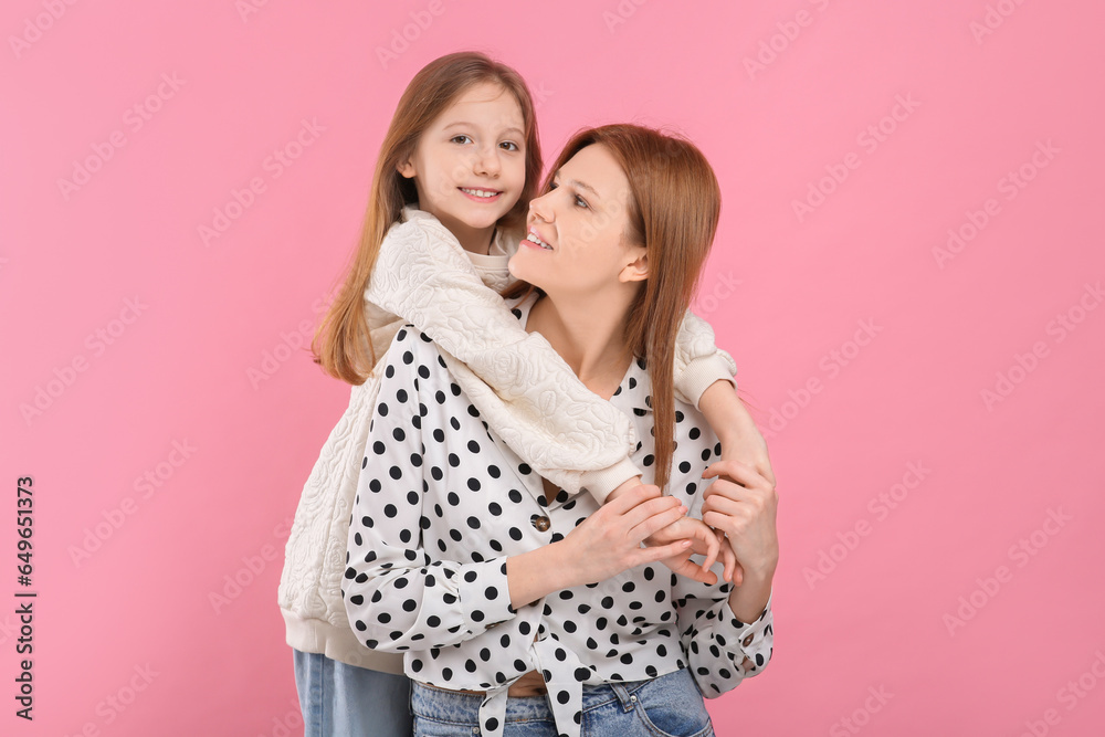 Portrait of happy mother and her cute daughter on pink background Portrait of happy mother and her cute daughter on pink background