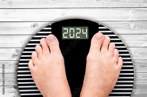 2024 feet on a weight scale, nutrition and diet new year card photo