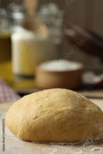 Raw dough and flour on table, closeup