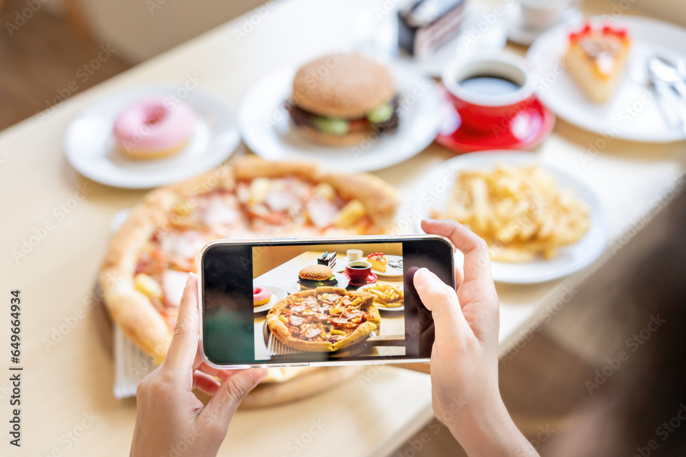 Φωτογραφία restaurant owner takes a picture of the food on the table with a smartphone to post on a website