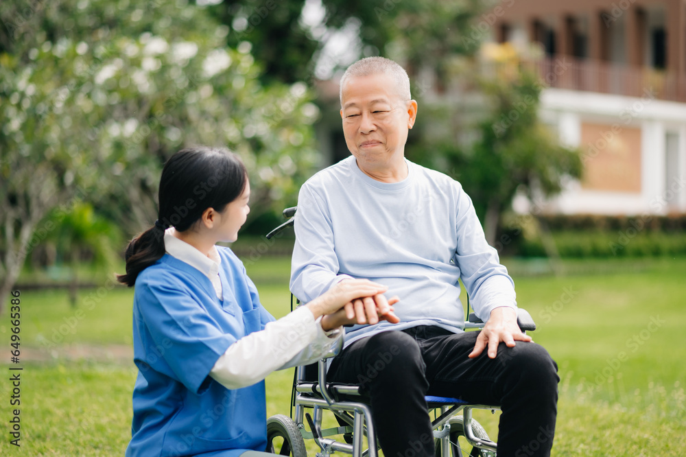 Elderly asian senior man on wheelchair with Asian careful caregiver. Nursing home hospital garden concept. Elderly asian senior man on wheelchair with Asian careful caregiver. Nursing home hospital garden concept.