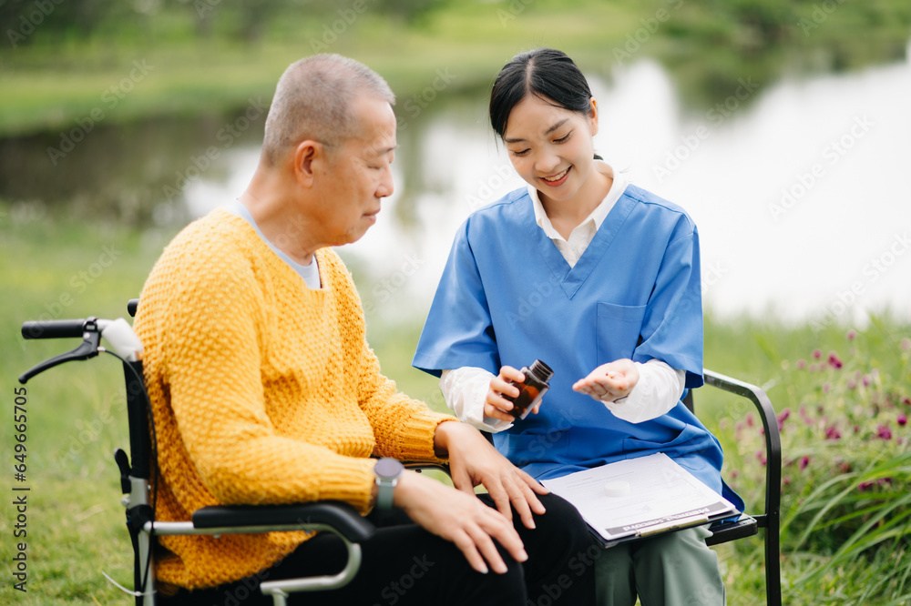 Elderly asian senior man on wheelchair with Asian careful caregiver. Nursing home hospital garden concept. Elderly asian senior man on wheelchair with Asian careful caregiver. Nursing home hospital garden concept.