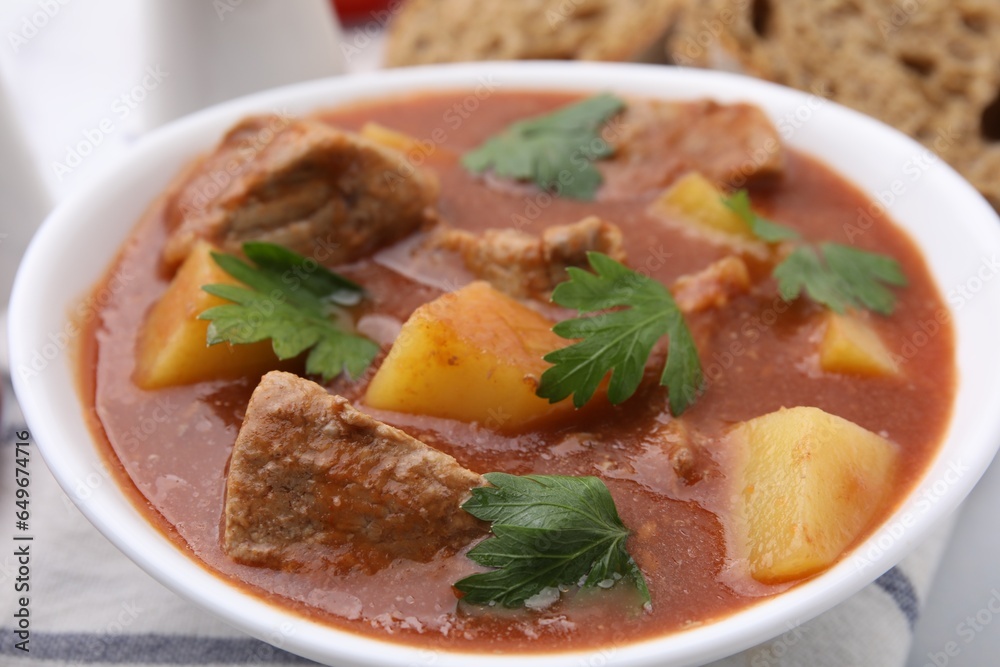 Delicious goulash in bowl on table, closeup Delicious goulash in bowl on table, closeup