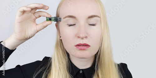 Usb memory stick in head. Flash drive to brain. Girl stands with memory card in her hand and wants to insert it into her body. Cybernetization and rapid learning technologies. Improving your own mind photo