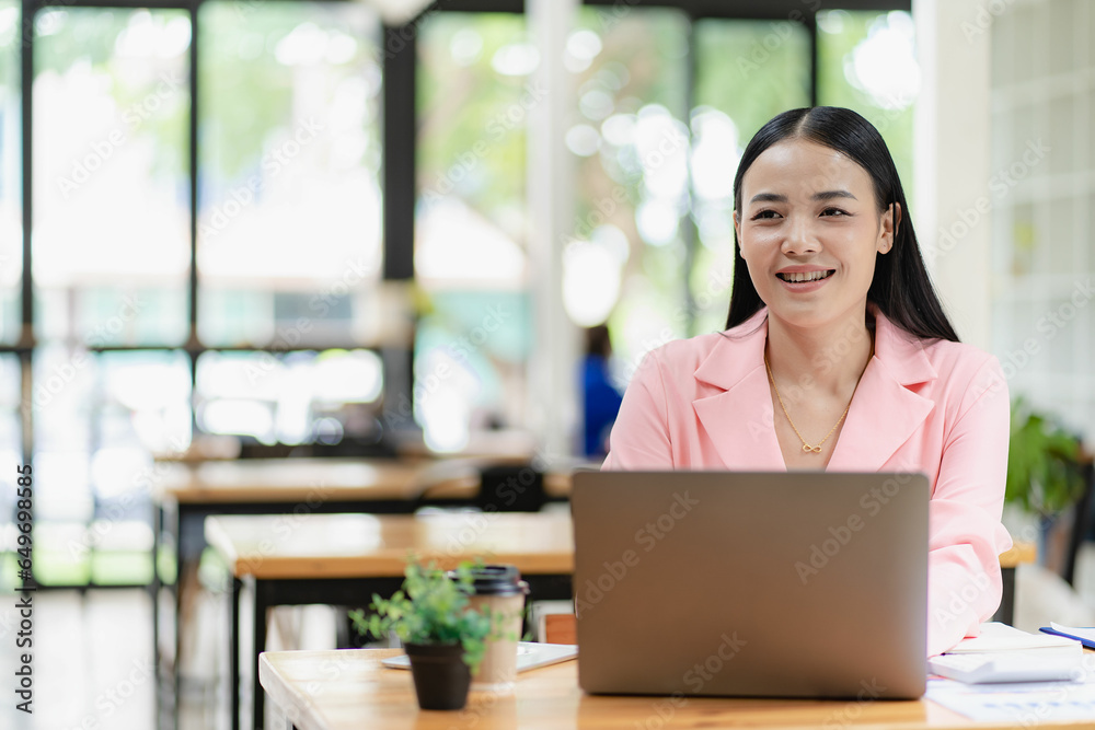 Asian businesswoman using laptop computer with documents The notebook is on the table. Report analysis planning Financial statistics Asian businesswoman using laptop computer with documents The notebook is on the table. Report analysis planning Financial statistics
