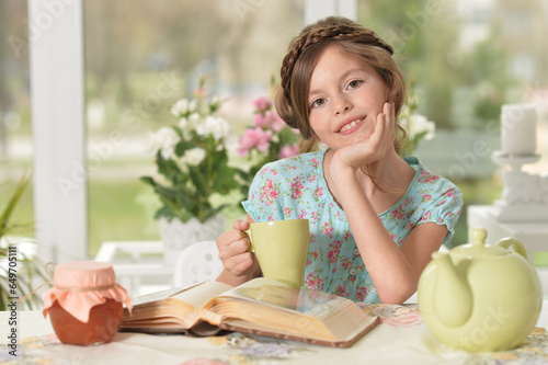 Close up portrait of young girl reading interesting big book