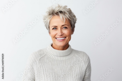 portrait of a Polish woman in her 50s wearing a cozy sweater against a white background