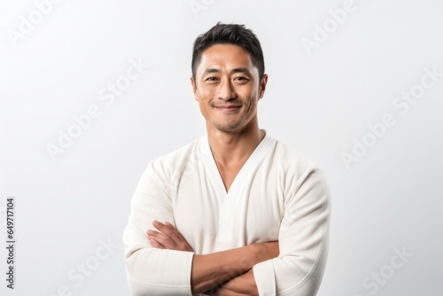 portrait of a confident Filipino man in his 30s wearing a chic cardigan against a white background