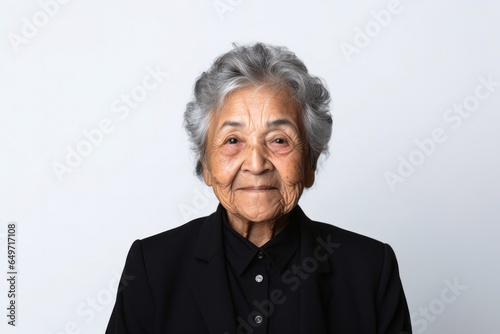 portrait of a confident 100-year-old elderly Mexican woman wearing a sleek suit against a white background