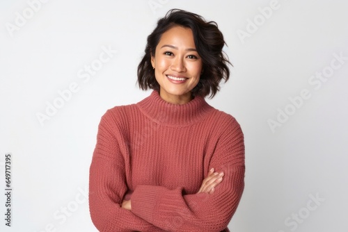 portrait of a confident Filipino woman in her 30s wearing a cozy sweater against a white background