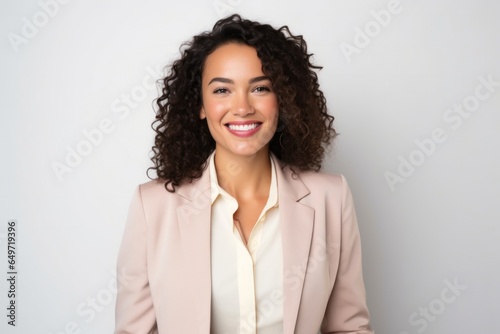 portrait of a confident Mexican woman in her 30s wearing a classic blazer against a white background