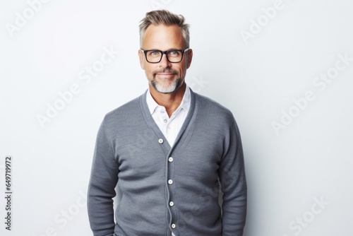 portrait of a confident Polish man in his 40s wearing a chic cardigan against a white background © Robert MEYNER