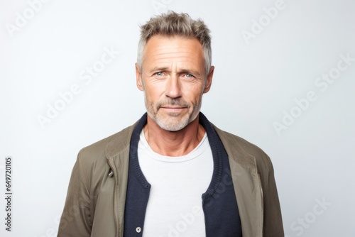 portrait of a confident Polish man in his 50s wearing a chic cardigan against a white background