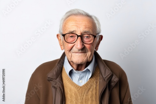 portrait of a confident Polish man in his 90s wearing a chic cardigan against a white background © Robert MEYNER